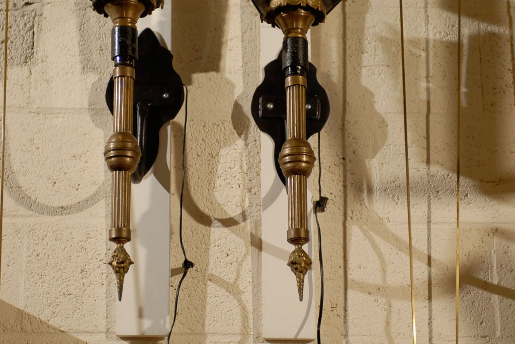A pair of large coach lanterns constructed in brass and iron, each with four sided glazed glass panels and drapery design, dating from the 19th century and English in origin.  <br />
<br />
For many more fine antiques, please visit our online