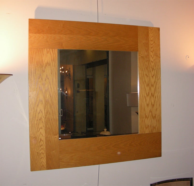 Large 1970s mirror with wide light wood frame.