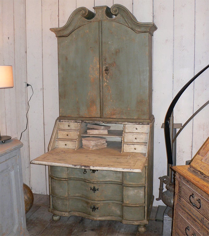 1850s armoire with central section composed of a flap-down writing surface and 6 small interior drawers. Upper unit has two doors and 3 interior shelves; lower unit has 3 drawers. Re-patinated in green and white. Open depth 95 cm.