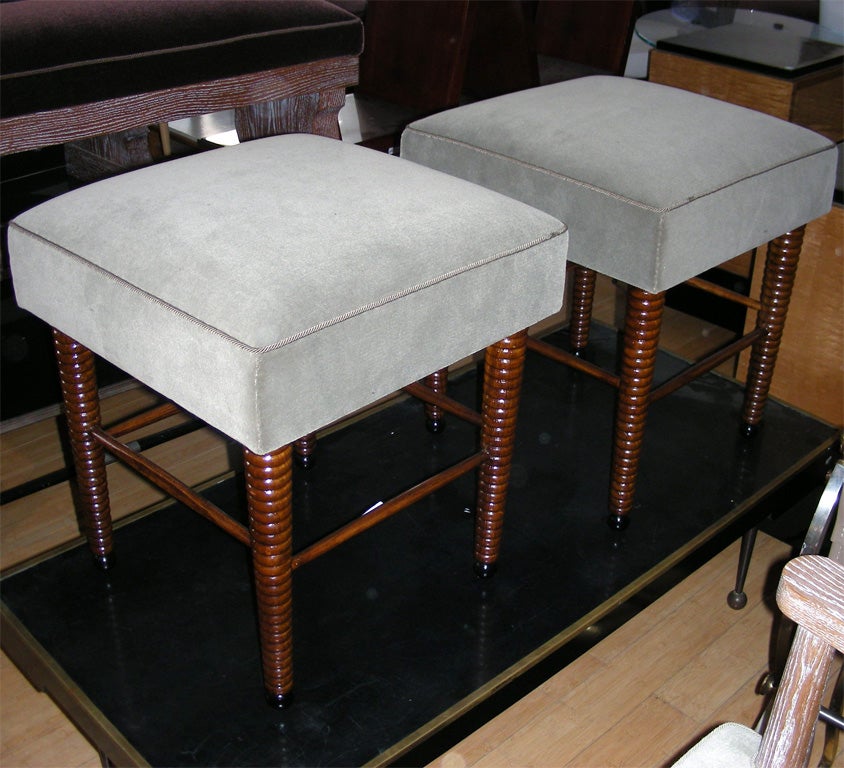 Two 1930s stools by Jansen with legs in turned walnut, re-upholstered in velvet.