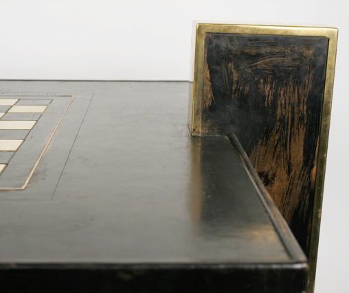 1960-1980 coffee table  clad in black leather and edged in gilt bronze, with a central checkerboard.