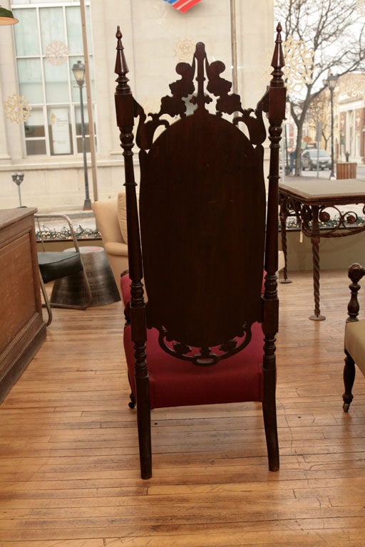 A matched pair of chairs in the Gothic Revival style. Mahogany, with crisp carving and turnings.  Probably made in Boston, for a Gothic manor in Maine.  Foliate carving offsets the strong architecture and turnings. The front legs retain their