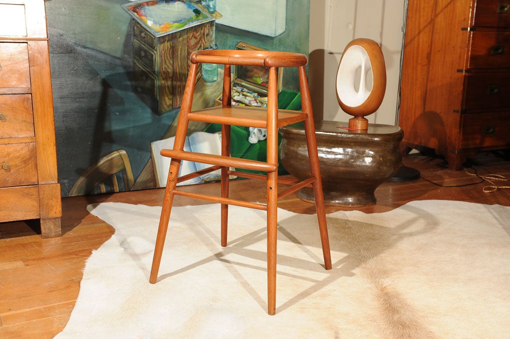 solid teak child's chair with adjustable foot rest and removable safety bar designed by Nanna Ditzel 1923-2005