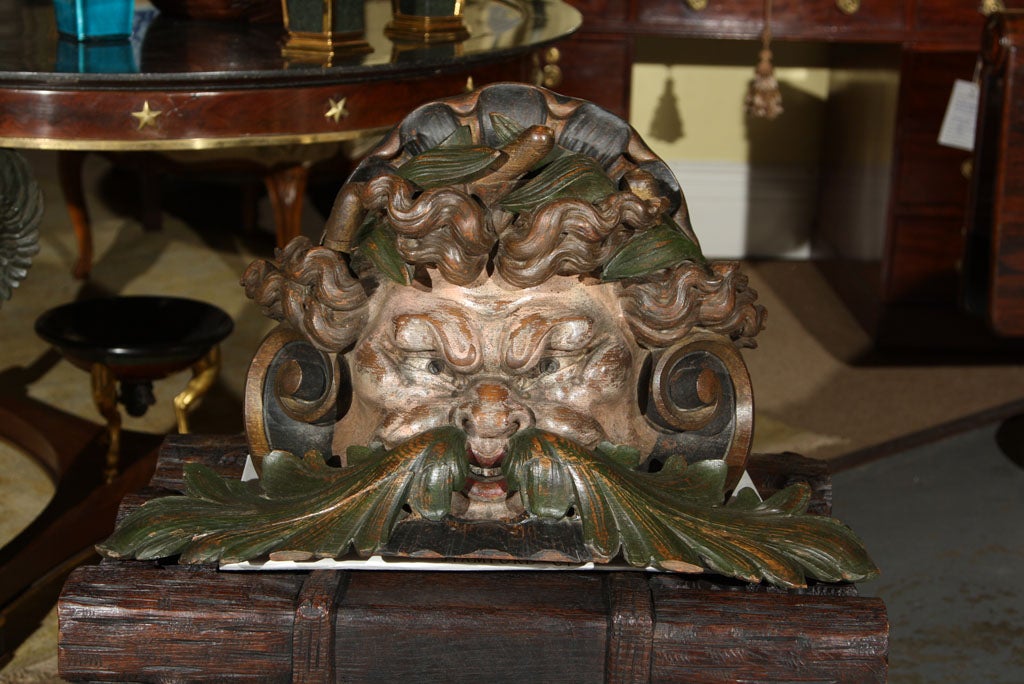 A maritime architectural element of painted and carved wood representing Neptune.