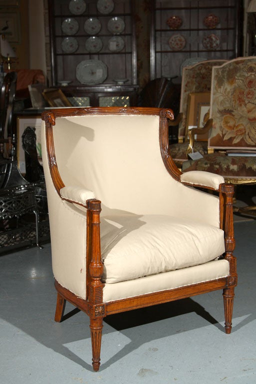 A French 18th century Louis XVI neo-classical mahogany upholstered armchair covererd in muslin.