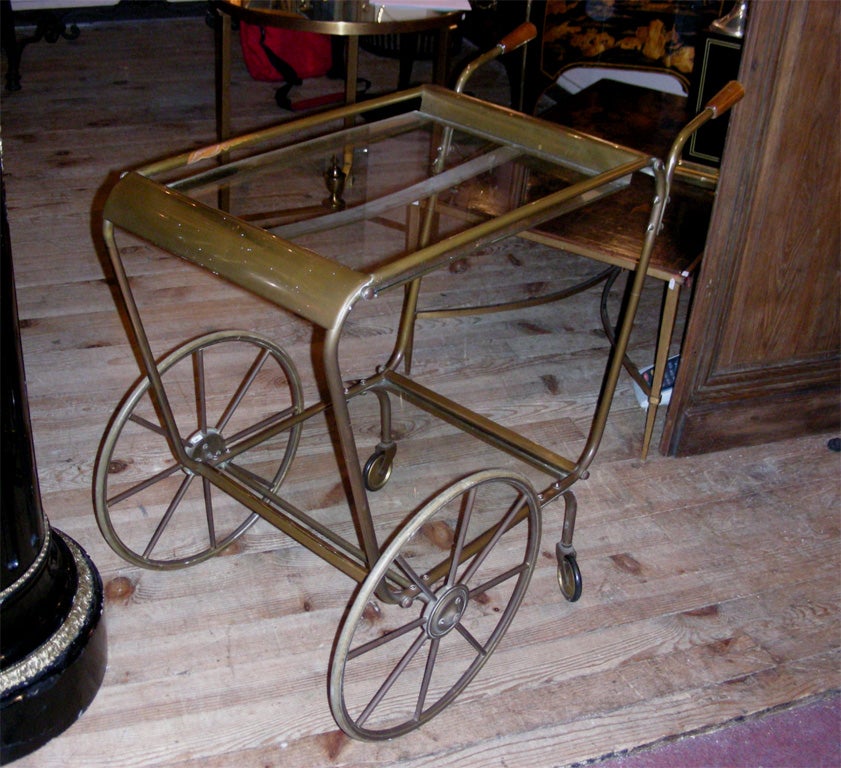 1950s rolling table in gilt brass with two shelves in glass.