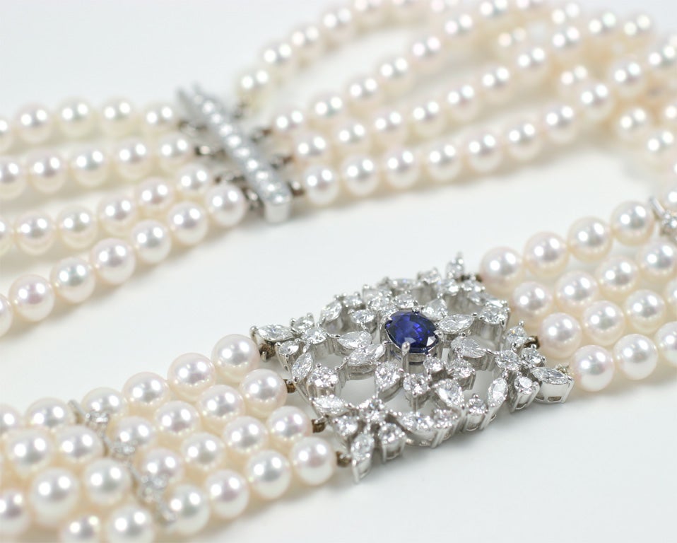 Mikimoto collar necklace, set with 44 diamonds weighing 6.15 cts, F-G VS, platinum. A center no heat sapphire weighing 2.05 ct and a platinum clasp containing 9 F-G VS diamonds weighing 0.46 Carats. There are 4 rows of 7mm AA Mikimoto pearls.