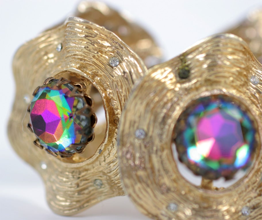 Five undulating gilt round disks studded with small clear rhinestones and centered with large round cut aurora borealis rhinestones.