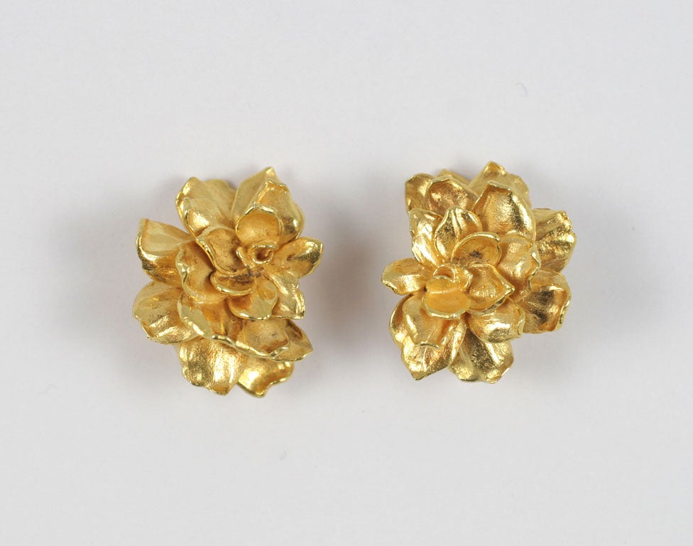 Sandra Yunis was a well-known jewelry designer who worked for Tiffany & Co. in the 1960’s. The gold stylized flowers bring this beautiful set of clip-on earrings and a brooch, adorned with a small diamond on one of the petals, to life.  Brooch