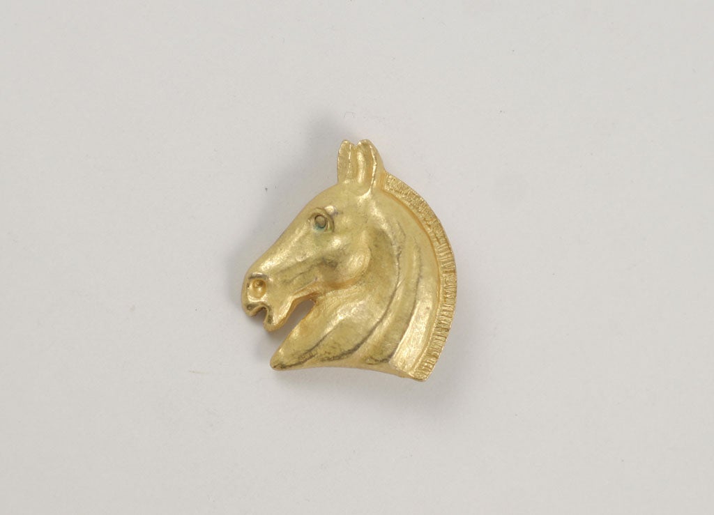 Beautifully detailed small gilt Hermes horse head pin. The Hermes insignia velvet bag and orange Hermes box are included. Signed: Hermes Paris Bijouterie Fantaisie.