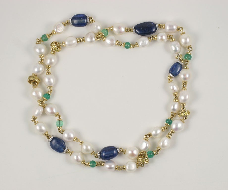 18k yellow gold kyanite, emerald and baroque pearl long necklace with diamond and yellow sapphire accents.
