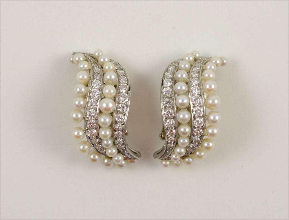 These elegant pearl and diamond clip- earrings once belonged to the great drama queen Joan Crawford! A graceful S- curve design is realized in platinum with two rows of interchanging diamonds and pearls.