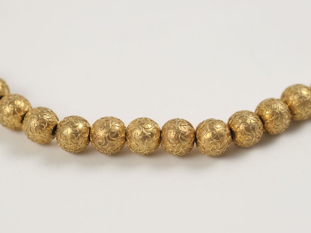 A delicate gold necklace of beads encrusted with golden strands that interweave and completely cover each bead. Without the help of a loup, the beads appear granulated as were their c.1870 etruscan revival cousins. The necklace, strung on strong