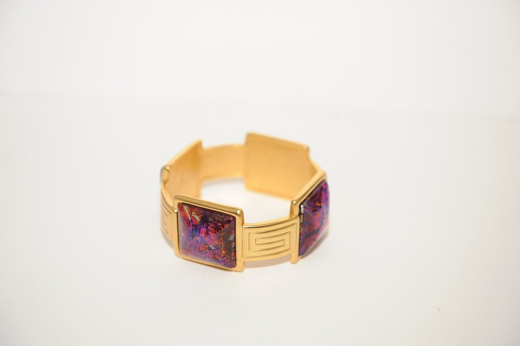 GOLD GILT METAL AND ENAMEL BRACELET MADE BY YVES ST LAURENT,FRANCE.THE ENAMEL PANELS MEASURE 1 1/4 INCHES BY 1 1/4 AND THE GILT CONNECTORS ARE HALF AN INCH IN DEPTH.THE BRACELET IS SIGNED YSL IN AN OBLONG PANEL ON THE INSIDE OF ONE OF THE ENAMEL