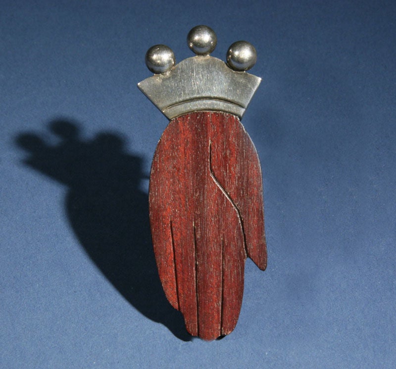 A whimsical  brooch of a hand by the American master designer, William Spratling, who worked in Taxco, Mexico.  The clip brooch is accentuated by the mixed materials, that Spratling often combined.  He was also fascinated by the hand, which he used