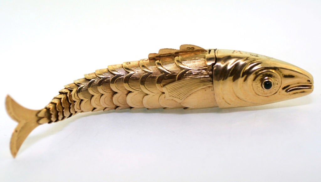 Designed as a highly articulated fish. Set with one sapphire and one emerald cabochon eye. French assay marks for gold and signed Tiffany Schlumberger. Model 1939.