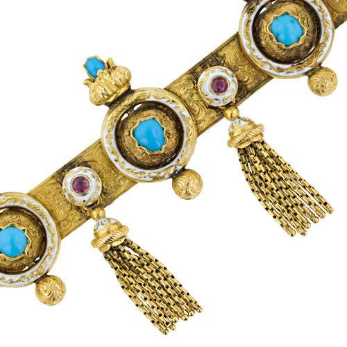 The sensual design and color combination of this magnificent and exotic antique bracelet form the mid-to-late 1800's is evocative of the mysterious east. Six tassels dance and sway below ruby and white enamel buttons which alternate with turquoise