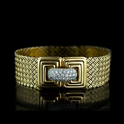 A fabulous, stylish and hefty 18k yellow gold fashion bracelet from the swingin' sixtie's. The top of the bracelet features a woven mesh design and the back is composed of a bright polished scale pattern. The intricately designed geometric clasp and