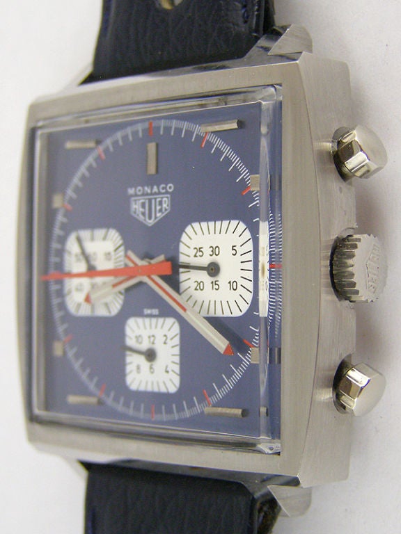 Heuer SS original vintage 1970s Monaco 41 X 47mm square case with blue metallic dial with white registers and applied silver indexes.17 jewel manual wind movement with signed Heuer crown on Heuer perforated strap with signed Heuer buckle. Correct