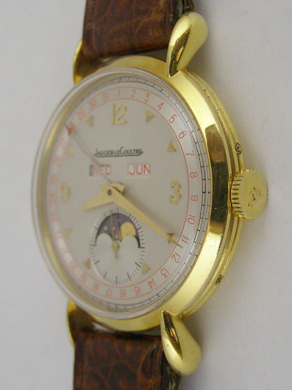 Magnificent pristine condition large 37 X 51mm lobed lug triple calendar<br />
moonphase Jaeger Lecoultre 18K YG circa 1950's. Mint condition original 2<br />
tone dial with red outer calendar track, red month and day disk, red arrow<br />
tipped
