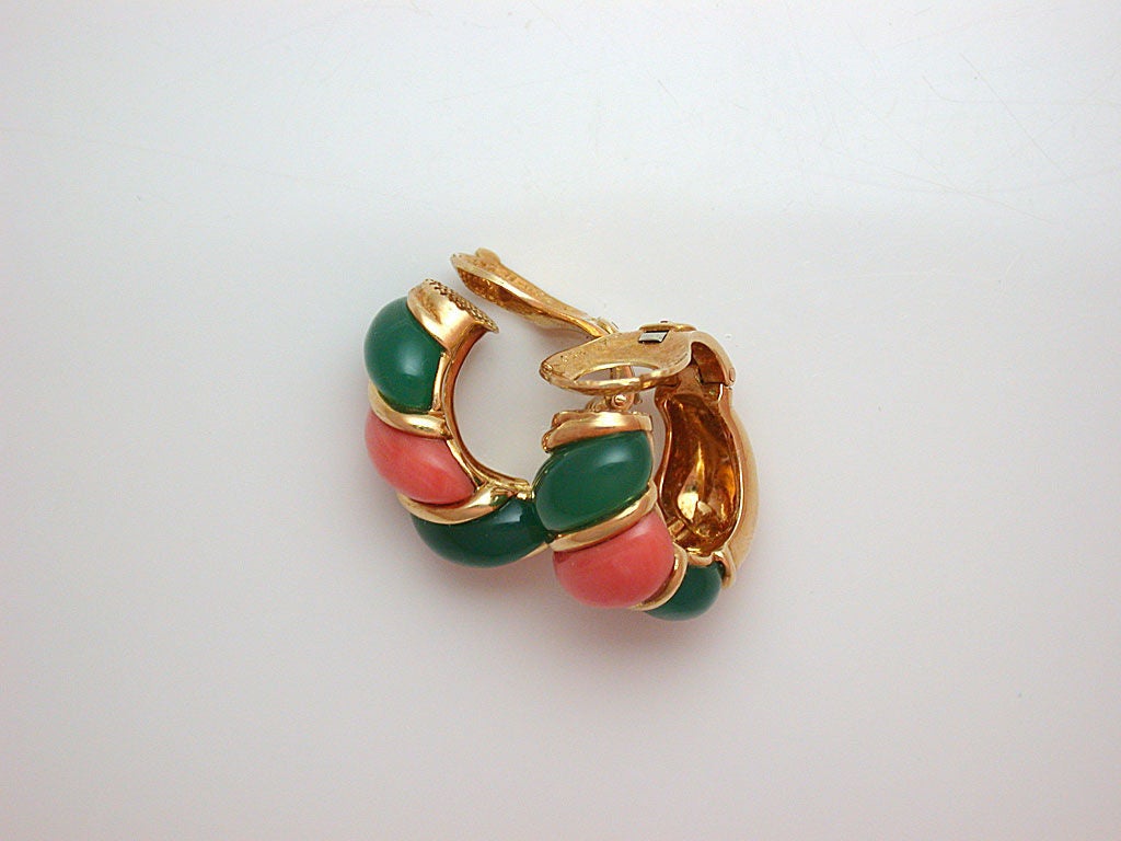 The domed half-hoop earclips designed as twisted segments of carved orange coral and green onyx (chrysoprase) separated by polished gold wire, signed VCA for Van Cleef & Arpels, numbered B3475 D6, stamped OR for 18kt gold, with French maker's marks