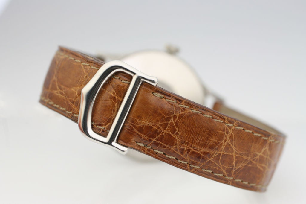 Dies ist eine äußerst seltene Cartier Datumsuhr in Edelstahl aus den 1950er Jahren.  Sie hat ein schönes Originalzifferblatt mit blauen Ziffern.  Der Kronenmechanismus ist ziemlich einzigartig und steuert die Einstellung der Uhr und den Kalender. 
