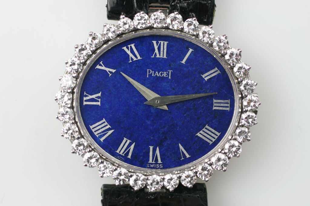 This is a Piaget ladies 18k white gold watch with (32) round prong set diamonds & Lapis dial. The case has 