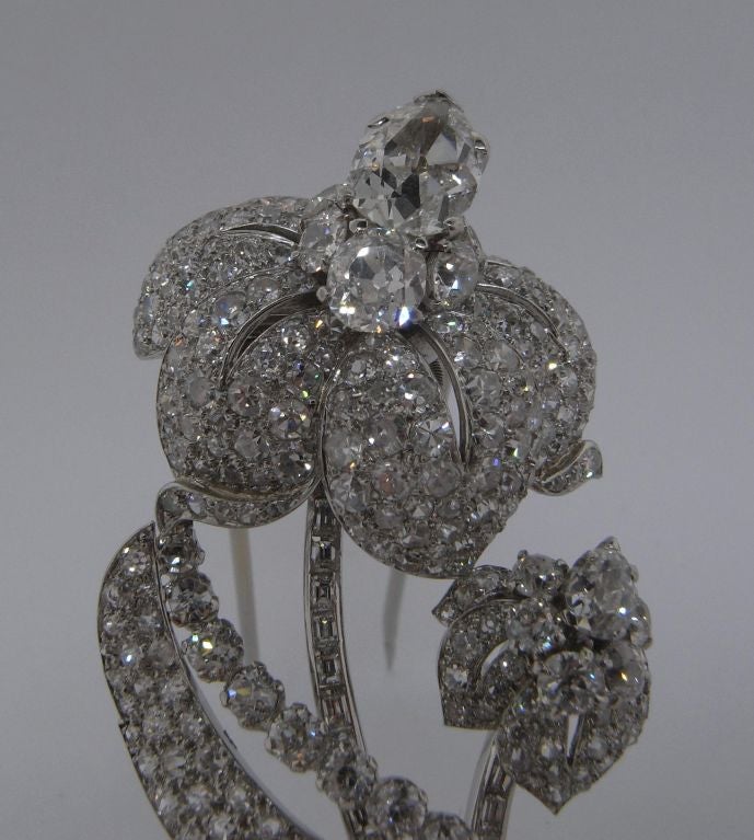 An incredible diamond flower brooch designed by Cartier London and with its original box.  The brooch is mounted to platinum, and is set with two pear-shaped diamonds, each weighing approximately 1.7 carats and 0.7 carats; and with 294 old cut and