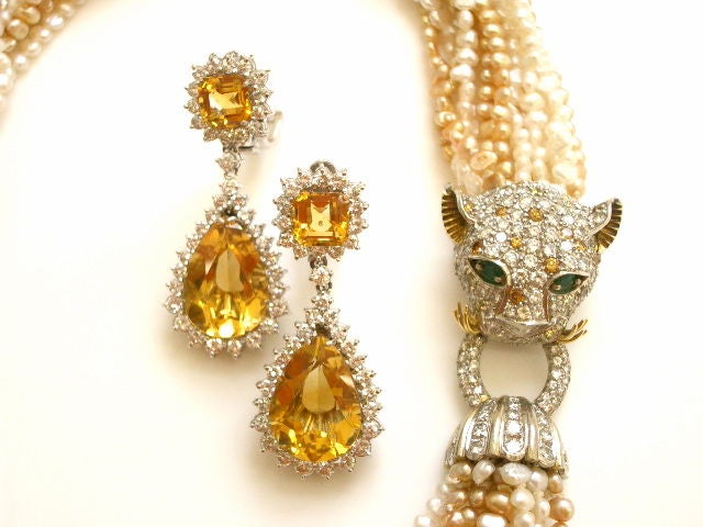 A charming 18k diamond and pearl torsade. The freshwater pearl necklace with a 5ct. bead set white and golden colored diamond clasp in the shape of a stylized panther's head ,accented with emerald eyes. The beautifully modeled serene panther wears