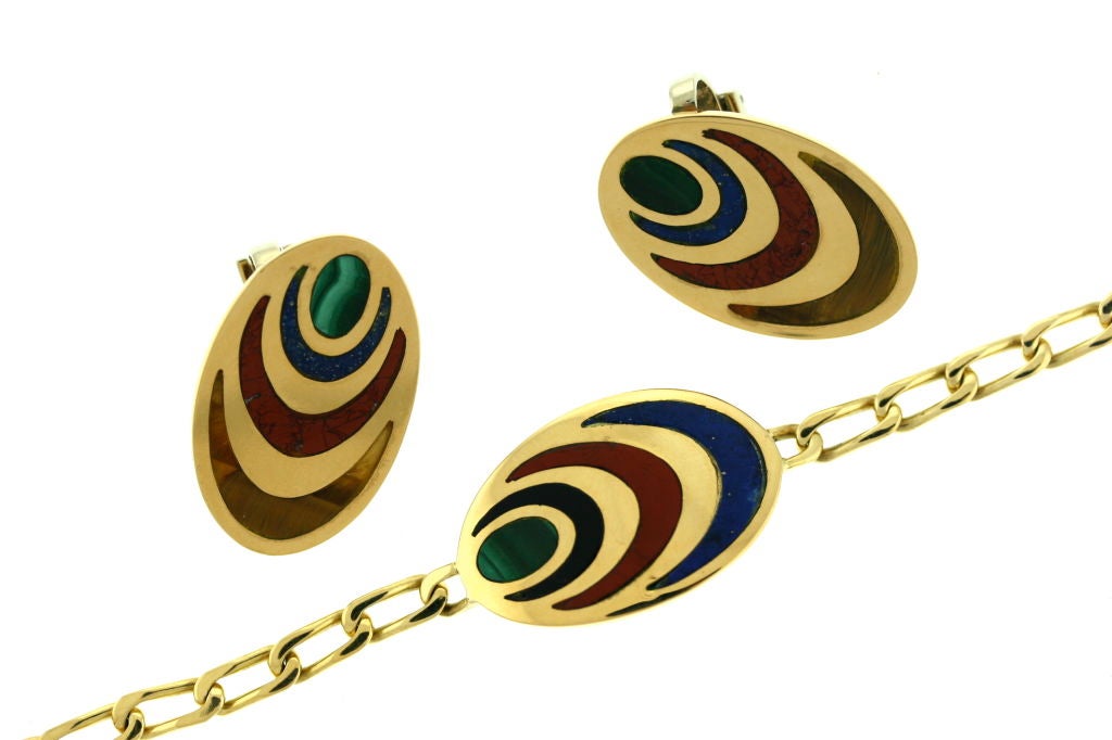 Colorful and whimsical 1970s Bulgari suite consisting of an 18k gold link bracelet with a central oval medallion inset with lapis, carnelian, onyx and malachite along with a matching pair of oval shaped ear clips inset with tiger eye, carnelian,