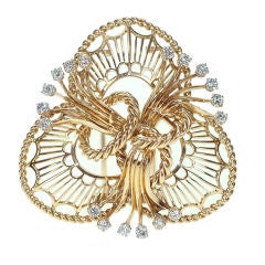 A gold and diamond trefoil knot brooch, by Boucheron