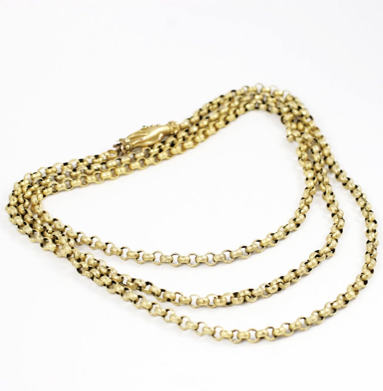 Long, round links, textured and covered with miniscule dots and stars form this 53 in chain. The links connect in alternating horizontal and vertical directions and were made by hand. The piece d'resistance is the original closure of two  hands