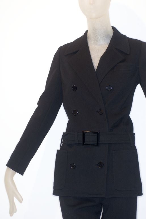 A classic 1960s Yves Saint Laurent black pantsuit.  The belt of the somewhat form fitting jacket sits on the hips.  The pants are fitted with a slight flair at the bottom.  Can't you just see Betty Catroux in Paris with Yves and the gang wearing