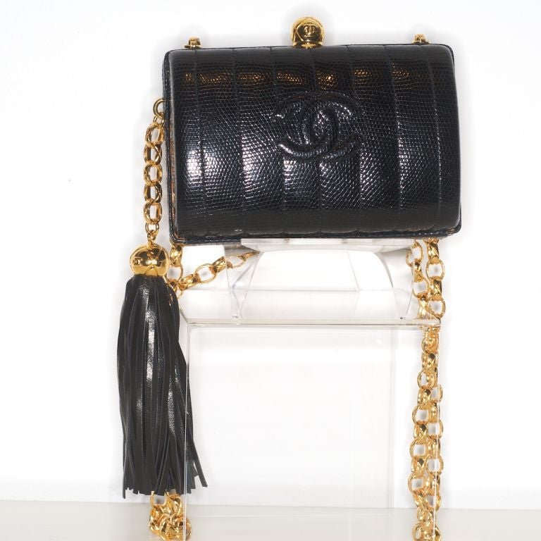 Beautiful, pristine and never used Chanel black lizard Chanel bag with tassel and gilt quilted effect chain strap.  Can also be worn as a clutch with its strap tucked in.
