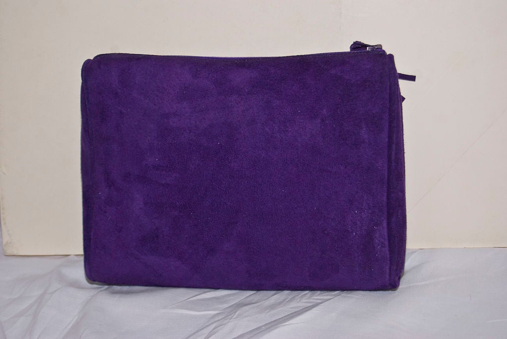 YSl purple suede clutch bag with zipper closure and fringed tassel pull. Front of bag has a 