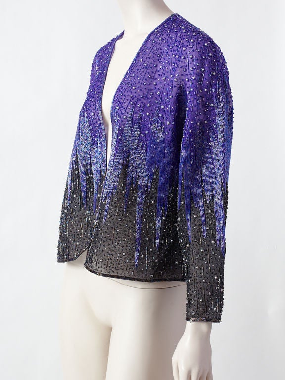 Halston, early 80's graphic design evening jacket in a deep shade<br />
of violet that gradually gets darker in tone in the jacket body and sleeve. The entire piece is heavily beaded on a silk organza, creating a sharp 