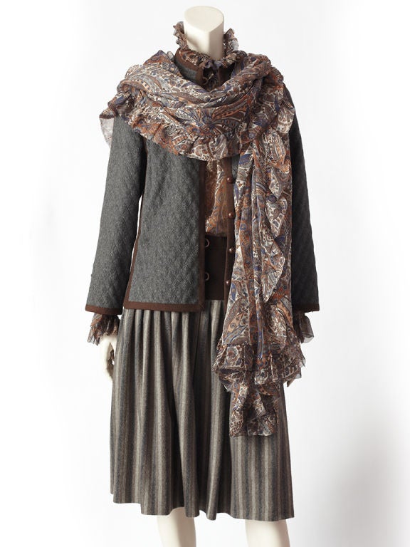 Yves St. Laurent 4 piece, couture ensemble composed of a silk chiffon blouse, matching scarf, quilted wool jacket and skirt.<br />
The silk chiffon blouse has a beautiful rich paisley pattern in tones of rust, grays, navy and brown. The blouse is