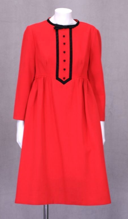 Geoffrey Beene 1960s red wool crepe baby doll dress with black satin bow and button decoration. Zip back entry.<br />
Excellent condition.<br />
Length: 38