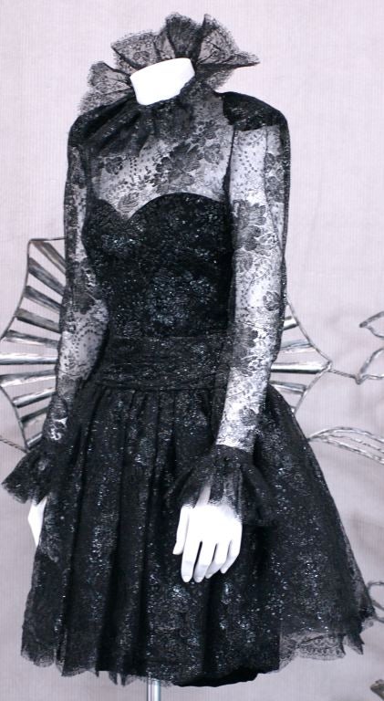 Lovely J.L Scherrer cocktail dress in black lacquered lace over black velvet boned bustier dress. Larged ruffled lace collar and cuffs. Covered lace buttons down the back provide entry and a gathered lace "waist" cinches the silhouette.