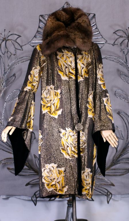 Extraordinary 1920's french lame art deco coat with orange, brown, cream and gold roses on a black and gold lame cubist leaf ground. Completely lined in black cotton velvet and topped by an oversized cape fur collar. The coat is worn wrap style