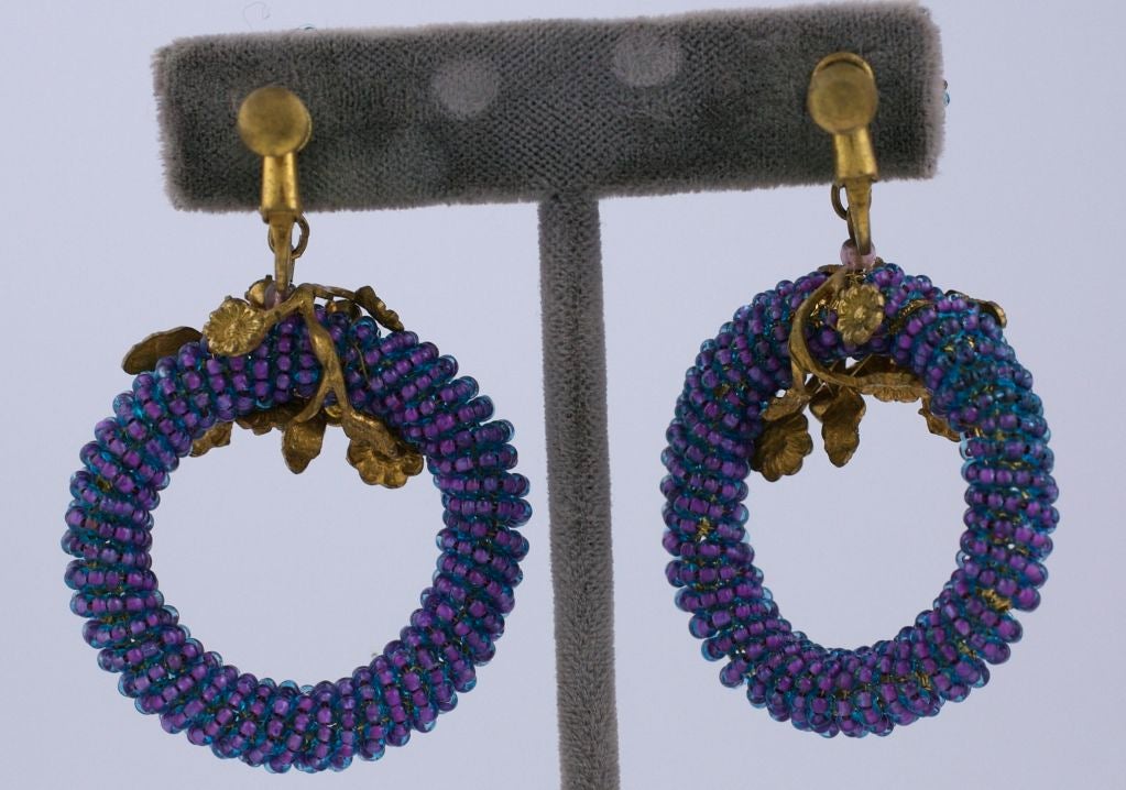 Pretty Miriam Haskell hoop earrings with intricate beadwork. 2 toned seed beads in pink and blue with magenta and iridiscent paste accents.<br />
Adjustable clip fixture.<br />
Unsigned<br />
Excellent condition<br />
Length 2.5