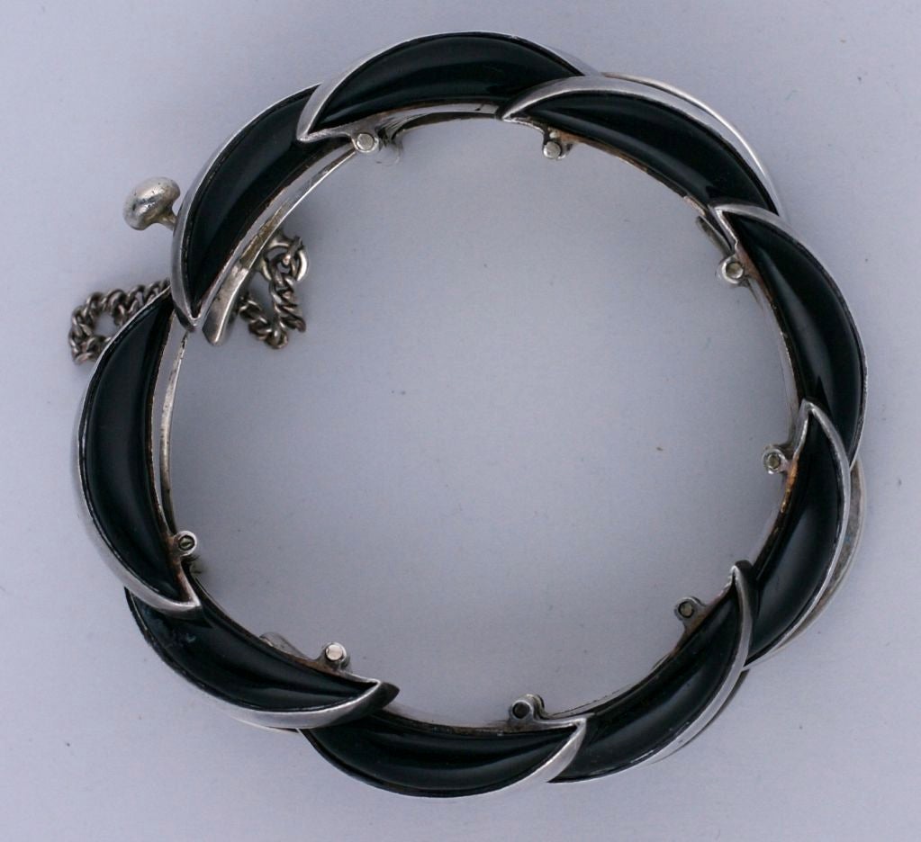 Strong, high style retro moderne cuff of long onyx crescent shaped stones set in articulated sterling silver. Extremely attractive and sculptural. This design is based on an Antonio Pineda design of the 1940s.This is a later adaptation probably from