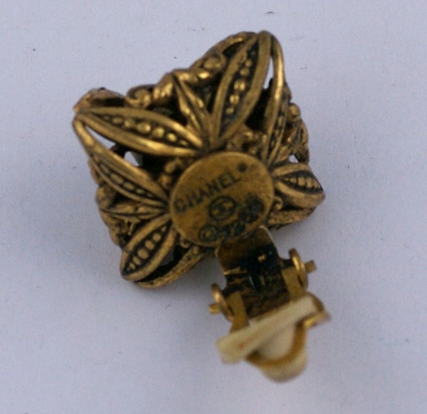 Hübsche Chanel-Ohrringe in antikem Gold. Filigraner Metallsockel, hervorgehoben durch Cabochon-Perlenimitat und Pasten. Klassischer Alltags-Ohrring.<br />
Signiert Chanel. 3/4
