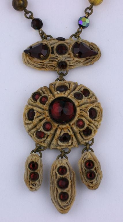 HENRY Necklace of hand carved and patinaed resin  set with ruby pastes.The pendant hangs from ruby pate de verre and faceted aurora  beads. Unusual ruby paste hook closure. Made in France circa 1950s. Henry was a contemporary of Line Vautrin and