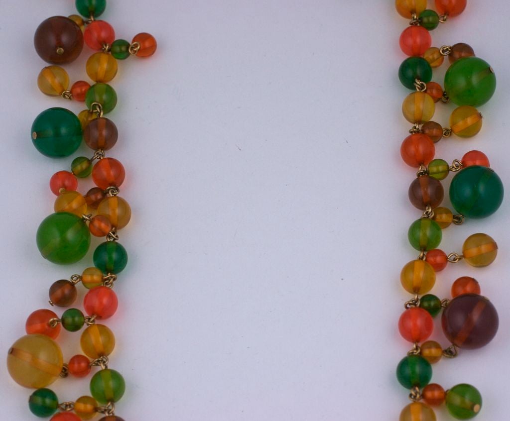 Lunga collana di perline in bakelite di diverse dimensioni e dai colori vivaci della frutta, risalente agli anni '60 circa. Dalla collana pendono anche molte perline. <br />
Condizioni eccellenti<br />
Lunghezza: 30