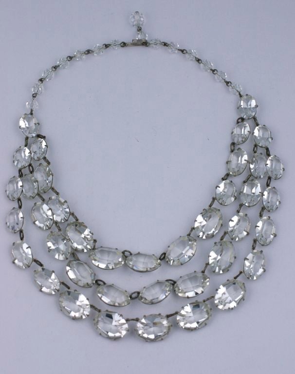 Unusually large bib necklace composed of 3 strands of claw set sparkling, oval glass pastes, attached to an adjustable crystal beaded back chain. 1930's USA. Excellent condition. 
16