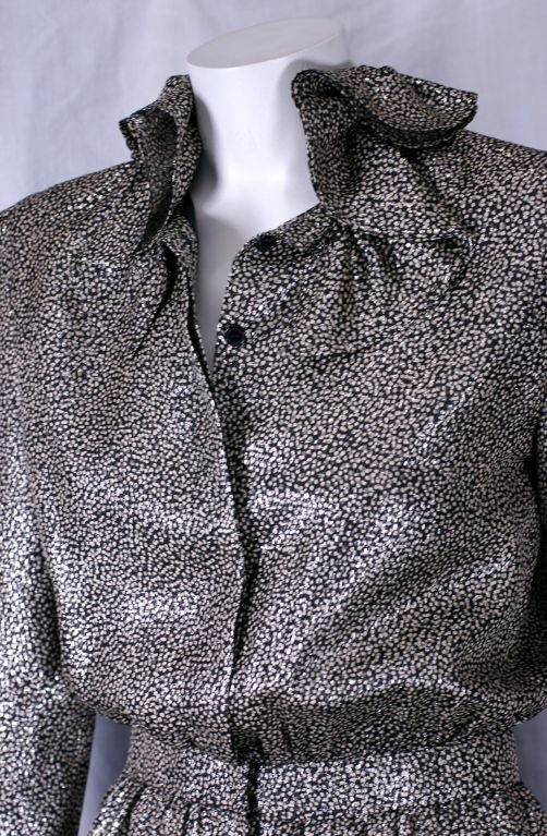 Ruffle collared lame blouse in black and silver stippled pattern with covered button front closure. Elasticized insert waist.   France 1980s.<br />
Excellent condition