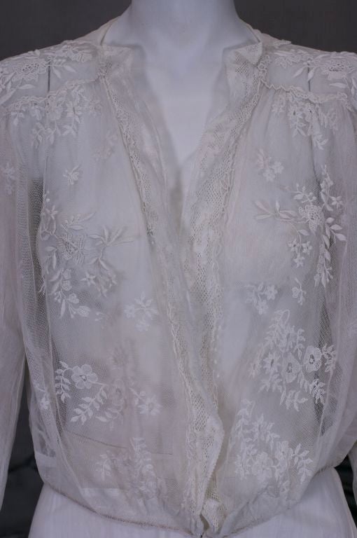 Lovely Edwardian cotton tulle blouse with embroidered floral sprays on front and cuffs. Handmade Lace trims the front of blouse which closes with a single snap closure at waist. Back is cut higher while the front is lower and slightly gathered as is