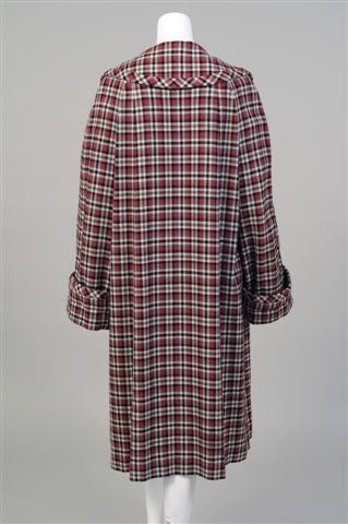 Jeanne Lanvin designed this coat in the early 1940's.  Fashioned from a cheerful red, grey and black on cream, the wool plaid coat has a wide collar, deep cuffs, and pockets concealed in the seams.  It is unlined and there are no closures, lending a
