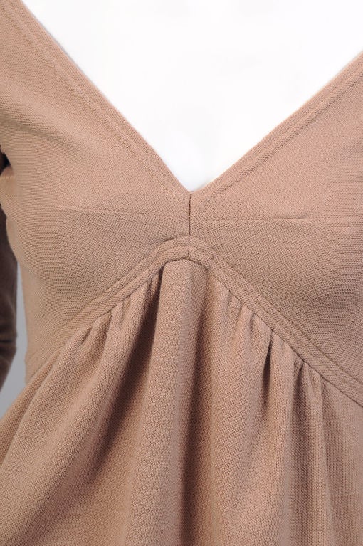 This is a sexy little mini dress from Rudi Gernreich, the man who invented the Topless bathing suit.<br />
A warm camel colored wool, the dress has a low neckline with horizontal darts, an Empire waistline that drops down to the natural waist in